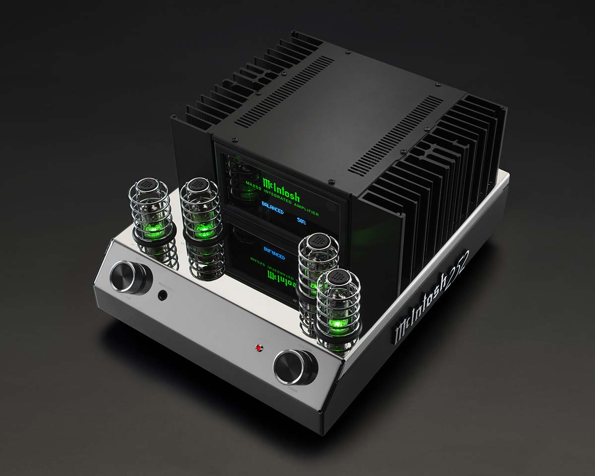 Sleek silver McIntosh amplifier with black accents, green-lit vacuum tubes, and two large knobs. Retro-futuristic design on a dark background.