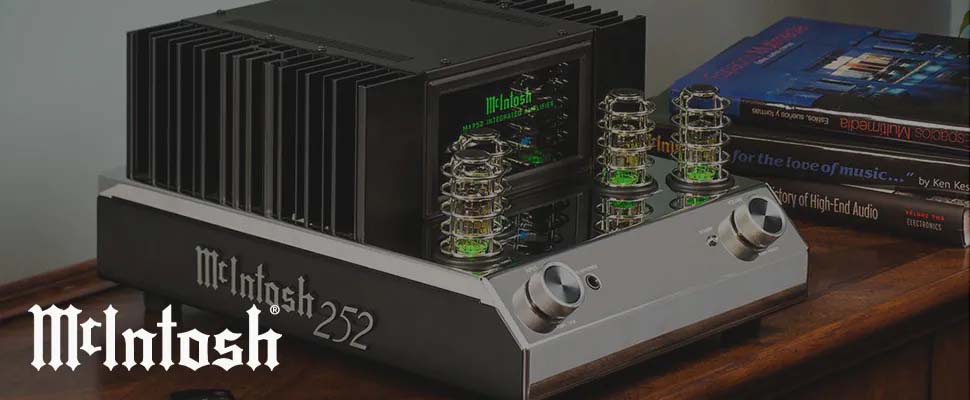 McIntosh 252 audio amplifier on a wooden table with glowing vacuum tubes, surrounded by books. The setting conveys a vintage, high-end audio vibe.