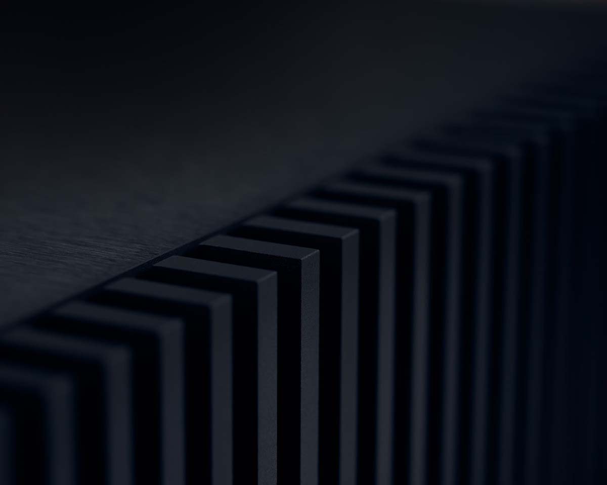 Close-up of a series of vertical, evenly spaced, dark rectangular fins casting soft shadows. The image conveys a sleek, modern, and minimalistic tone.
