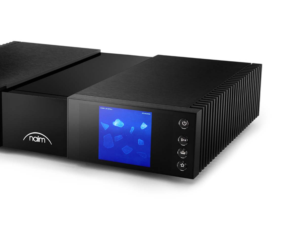 Black Naim audio device with a textured exterior and vertical venting. Blue screen displays abstract shapes, with control buttons alongside. Sleek and modern.