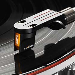 Close-up of a turntable needle on a spinning vinyl record. The sleek, modern arm features the brand name, hinting at quality audio equipment.