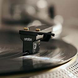 Close-up of a vinyl record being played on a turntable. The needle gently rests on the spinning black vinyl, evoking a nostalgic and vintage feel.