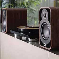 Two wooden speakers flank a modern turntable on a sleek cabinet. The setup exudes a vintage yet contemporary vibe, suggesting a love for music.