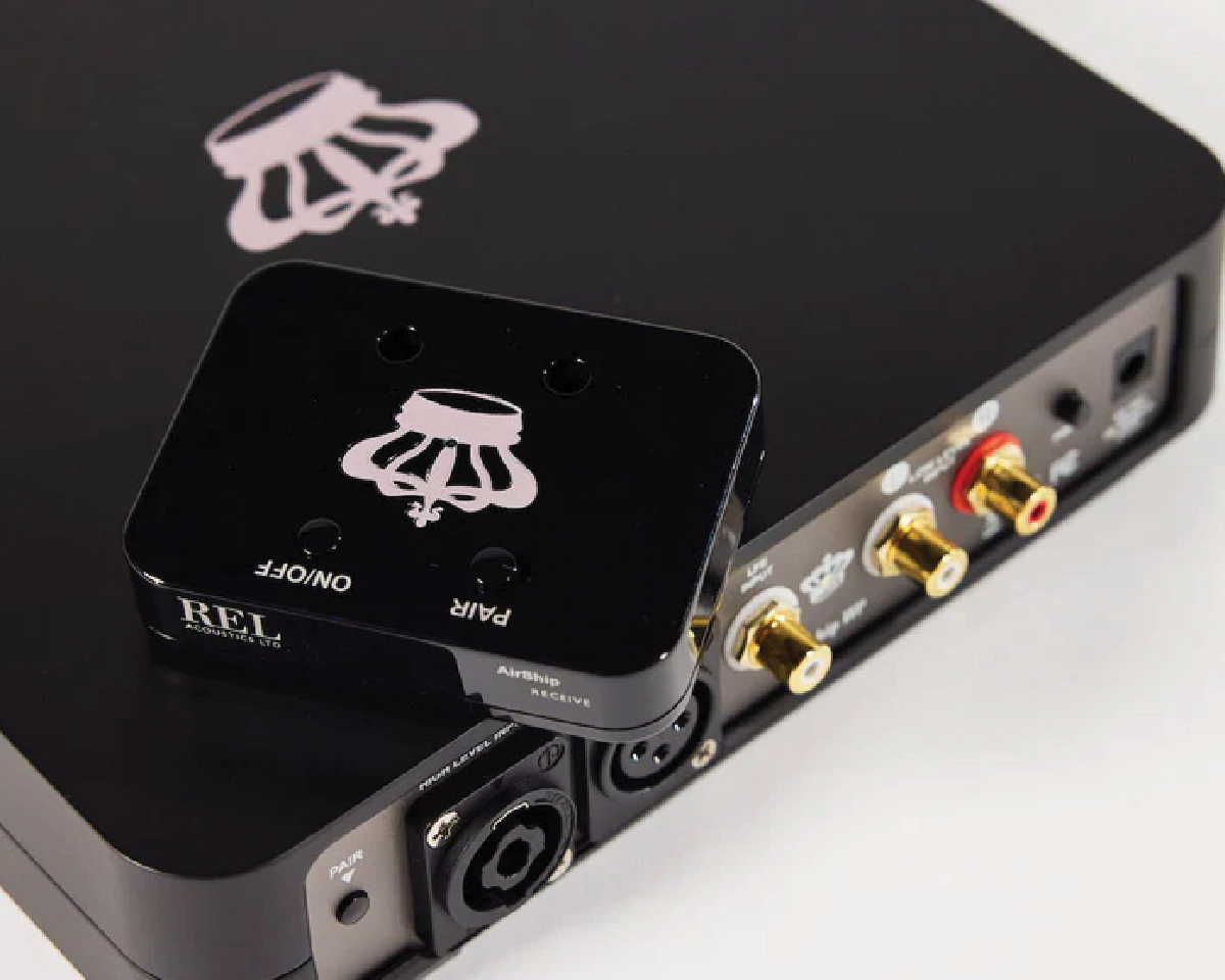 Black audio device with gold input connectors and a small black receiver on top, both featuring a crown logo. Buttons labeled ON/OFF and PAIR.