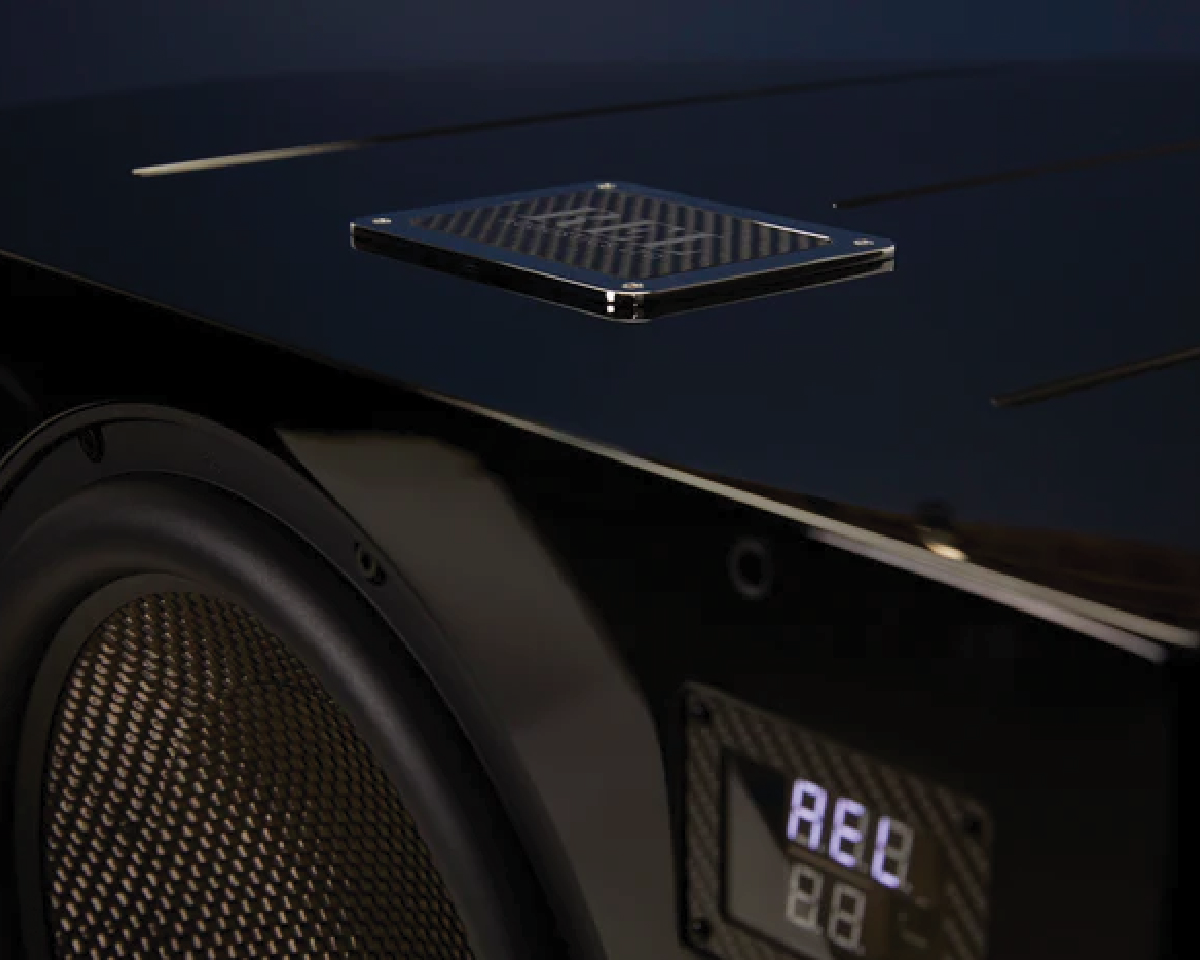 Close-up of a sleek, modern black audio device with a visible speaker grille and digital display. The reflective surface emits a sophisticated vibe.
