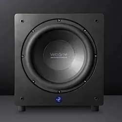 Front view of a sleek black subwoofer with a large circular speaker and four corner screws. A digital display shows "-2" at the bottom, set against a dark background.