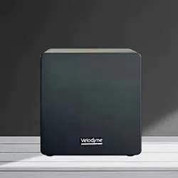 A sleek black Velodyne subwoofer sits on a light gray surface, casting a soft shadow against a dark gray background. The design is modern and minimalist.