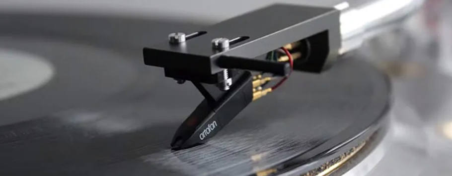 A close-up of a vinyl record player needle on a spinning black vinyl. The scene conveys a vintage and nostalgic mood, with a focus on music.