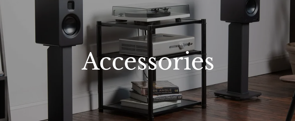A modern stereo system with sleek black speakers and a silver amplifier on black shelving. The text "Accessories" is displayed in white on the left.