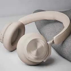 Beige over-ear headphones on a soft gray surface, showcasing a sleek, minimalist design. The lighting is gentle, evoking a calm, modern ambiance.