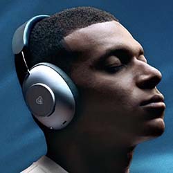 A person wearing large, sleek headphones with a peaceful expression. The background is a calming blue, conveying a serene and immersive listening experience.