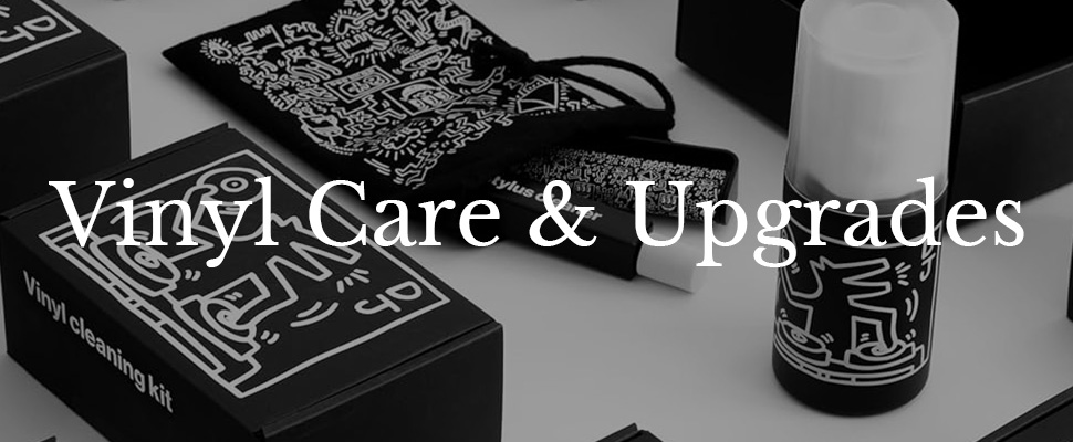 Vinyl cleaning kits and accessories with artistic designs are displayed. The mood is stylish and modern, highlighting "Vinyl Care & Upgrades" text.