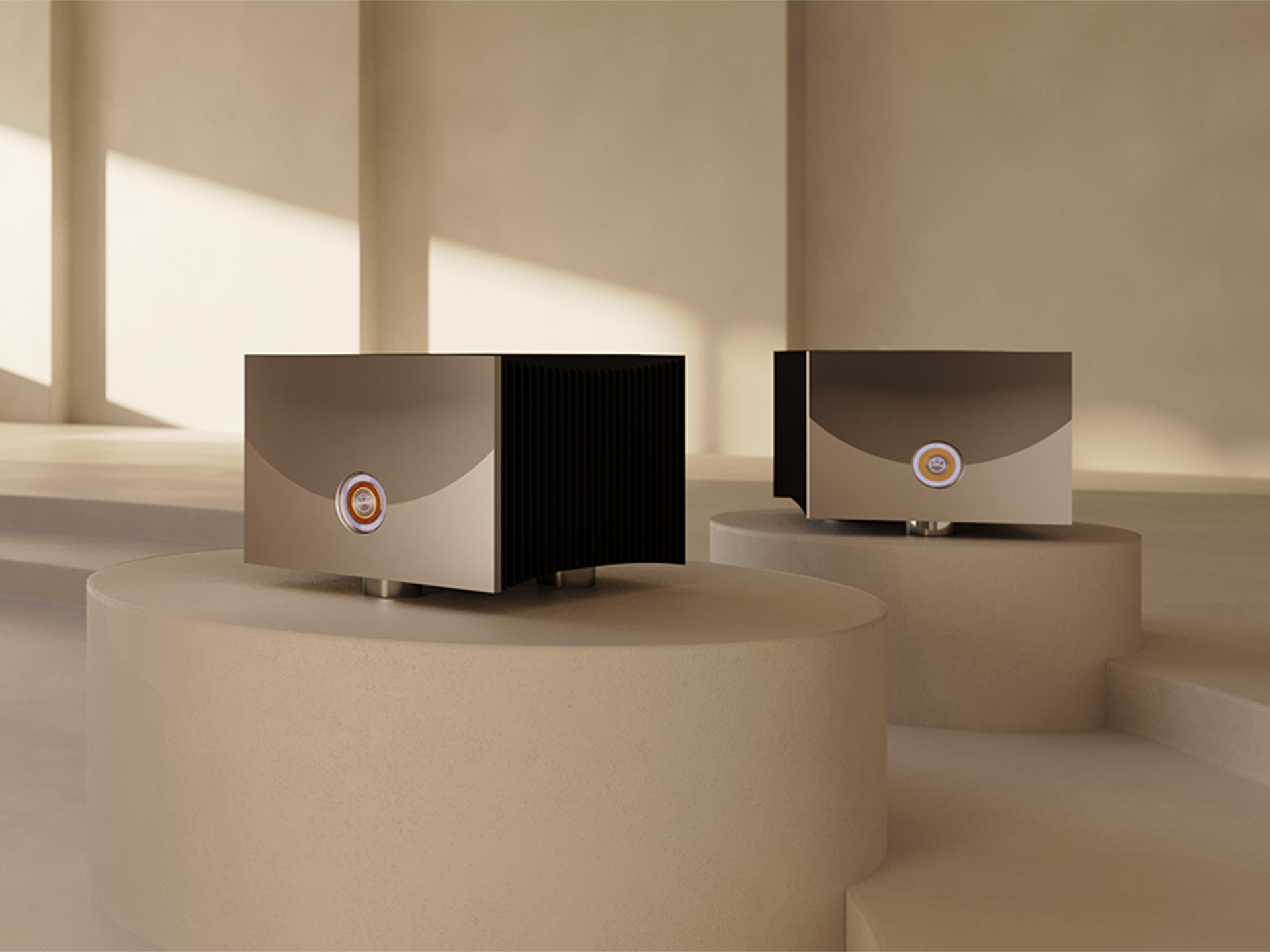 Two sleek, metallic audio amplifiers with a modern design are displayed on beige podiums in a softly lit room, evoking a minimalist, serene ambiance.