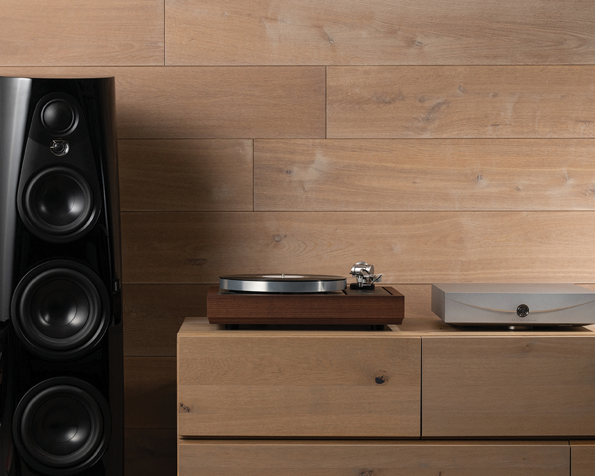 A modern living room with a sleek black speaker, a wooden turntable, and a silver audio unit on a wooden cabinet, set against a wood-paneled wall.