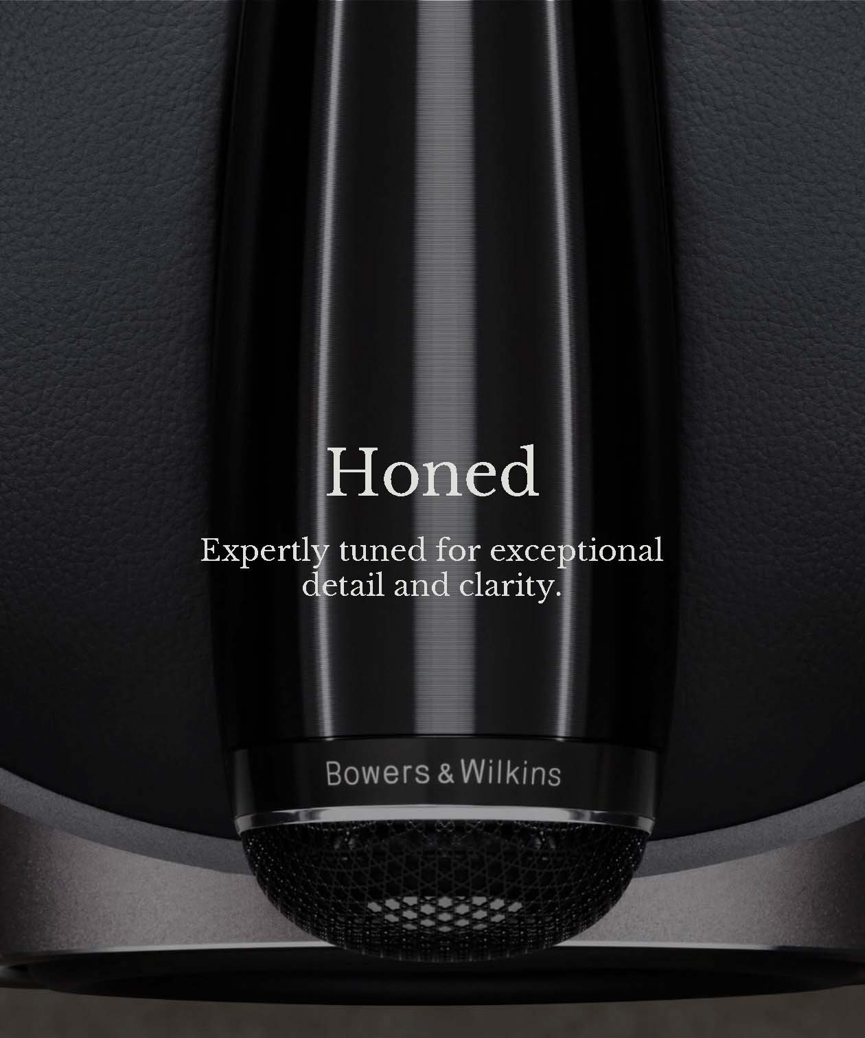 Close-up of a sleek, black Bowers & Wilkins speaker with text reading, "Honed. Expertly tuned for exceptional detail and clarity." Modern and refined.