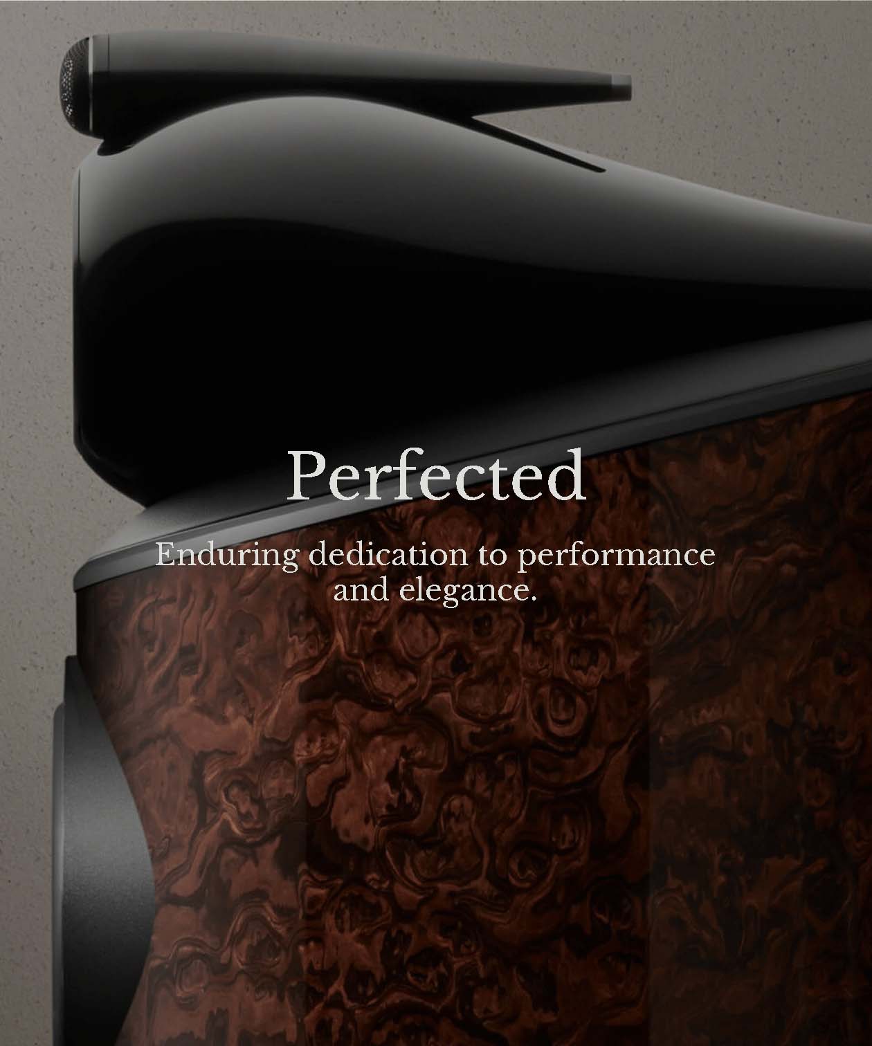 Close-up of a dark, sleek speaker with a glossy wood finish, conveying elegance and high performance. The text reads, "Perfected: Enduring dedication to performance and elegance."