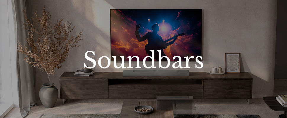 A modern living room features a sleek TV displaying a vibrant concert scene with a guitarist. Below, a soundbar sits on a stylish wooden console. The text "Soundbars" is overlaid.