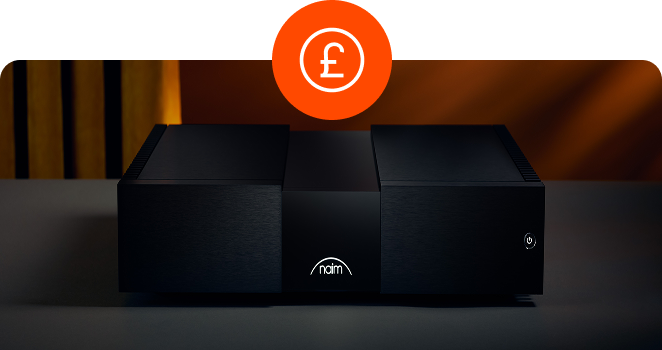 A black Naim audio power amplifier with an illuminated white brand logo on the front panel sitting on a grey surface, with a circular orange British pound currency icon overlaid at the top center.
