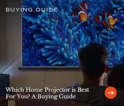 A couple watches a vibrant underwater scene with clownfish and coral on a home projector screen. Text reads "Which Home Projector is Best for You? A Buying Guide."
