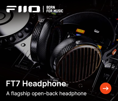 FiiO promotional banner for the FT7 headphones featuring the headline "FT7 Headphone" and subtext "A flagship open-back headphone". The image shows a close-up view of the premium open-back headphones resting on top of a dark, professional DJ mixer or media player console with lit buttons. The headphones highlight textured carbon fiber components on the headband structure, perforated leather ear pads, and a distinctive wood-grained outer grill casing. The white FiiO brand logo and slogan "BORN FOR MUSIC" sit at the top left corner, while a bright orange circular action button with a white right-pointing arrow is at the bottom right.