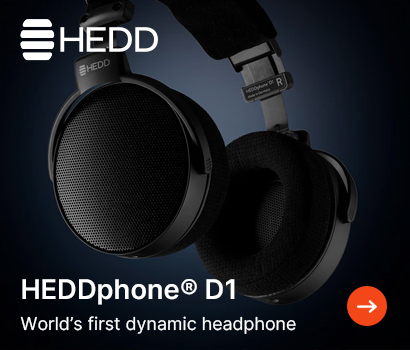 HEDD promotional banner for the HEDDphone D1 headphones featuring the headline "HEDDphone® D1" and subtext "World's first dynamic headphone". The banner showcases a close-up, floating view of the large, premium black over-ear headphones against a dark blue gradient background. The image clearly displays the fine mesh pattern on the outer open-back earcups, plush fabric earpads, and the adjustable metallic headband structure. The white HEDD brand logo is positioned at the top-left corner, and an orange circular action button with a white right-pointing arrow sits in the bottom-right corner.