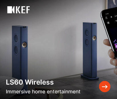 KEF promotional banner for the LS60 Wireless loudspeakers featuring the headline "LS60 Wireless" and subtext "Immersive home entertainment". The banner displays a modern interior with a pair of slim, royal blue floorstanding speakers flanking a wall. On the right side, a hand holds a smartphone showcasing a mobile audio player interface controlling the system. The white KEF brand logo sits at the top-left corner, and an orange circular action button with a white right-pointing arrow is located in the bottom-right corner.