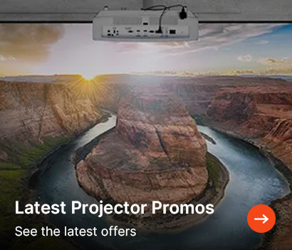 Promotional banner advertising the latest projector deals with the headline "Latest Projector Promos" and subtext "See the latest offers". The banner features a white projector mounted to a dark ceiling, projecting a large, vivid landscape image onto a wide projection screen. The projected imagery depicts a sweeping view of a winding river horseshoe bend within a canyon during sunrise. A round, orange button containing a white arrow pointing right is located at the bottom right corner.