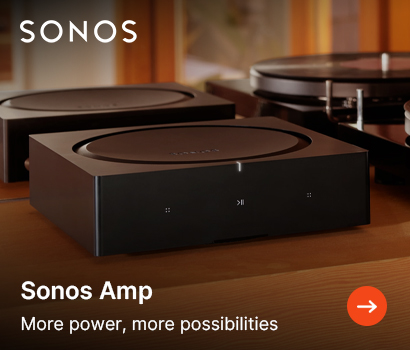Sonos promotional banner for the Sonos Amp featuring the headline "Sonos Amp" and subtext "More power, more possibilities". The banner shows a close-up, angled view of two sleek, matte black square Sonos Amp units stacked neatly on a warm wooden media shelf. A premium vinyl turntable is visible adjacent to the amplifiers in the warm, softly lit background. The white Sonos brand logo sits at the top left corner, and an orange circular action button with a white right-pointing arrow is located in the bottom right corner.