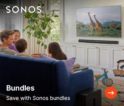 Sonos promotional banner for speaker bundles featuring the headline "Bundles" and subtext "Save with Sonos bundles". The banner shows a family of four sitting on a blue sofa together in a living room, watching a television that displays two giraffes in a safari landscape. A long black Sonos soundbar sits on a white cabinet below the television, and a black Sonos Sub is visible on the floor next to the couch. The white Sonos logo is positioned at the top left corner, and a bright orange circular action button with a white right-pointing arrow is at the bottom right.