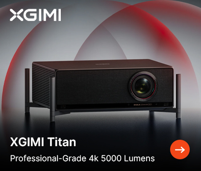 XGIMI promotional banner for the Titan projector. The image highlights a dark grey, high-end professional-grade projector resting on thin metallic corner legs against a grey background with sweeping red circular light trails. Text at the bottom left reads "XGIMI Titan" and "Professional-Grade 4k 5000 Lumens" next to a bright orange circular action button with a white right-pointing arrow, while the white XGIMI logo sits at the top left.