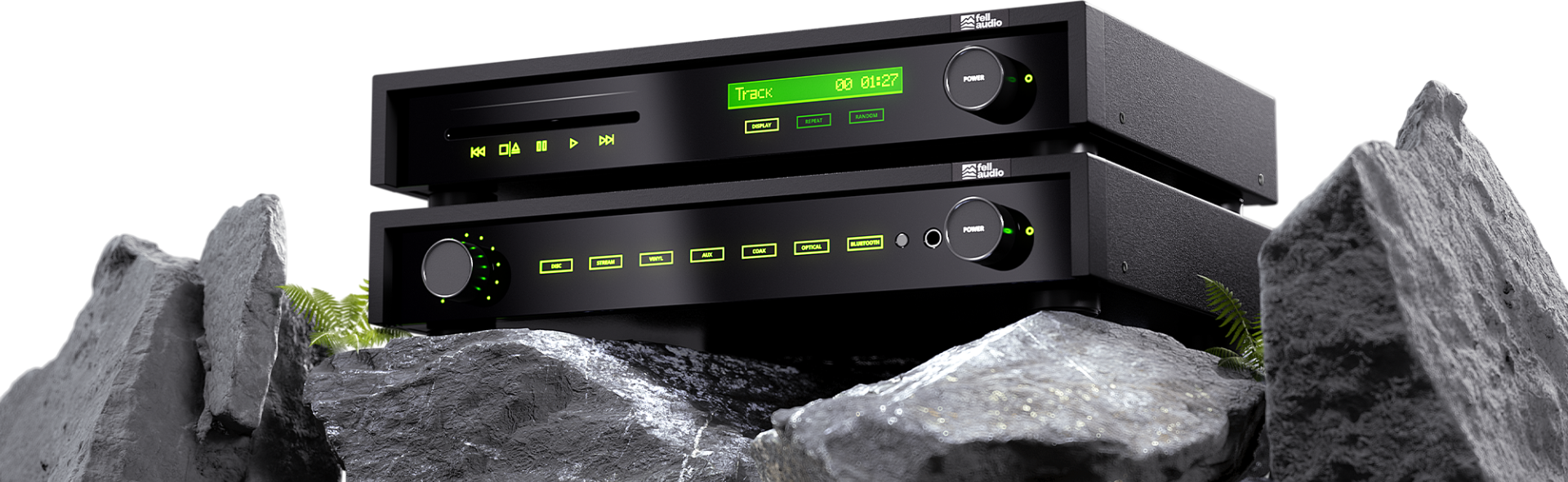 Stacked black audio equipment with glowing green LED displays, set on rugged grey rocks with small green ferns. Modern and sleek atmosphere.