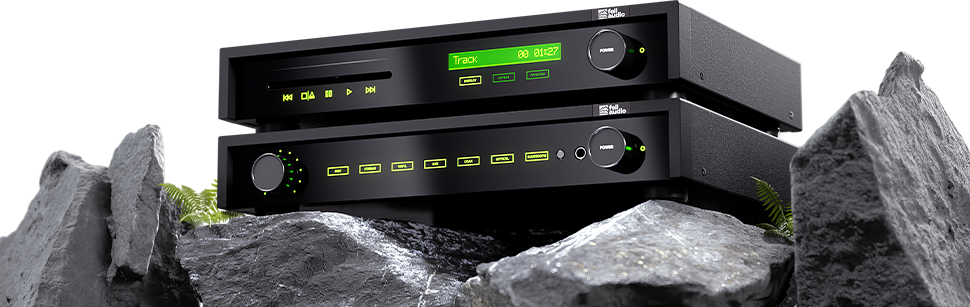 Stacked black audio equipment with glowing green LED displays, set on rugged grey rocks with small green ferns. Modern and sleek atmosphere.