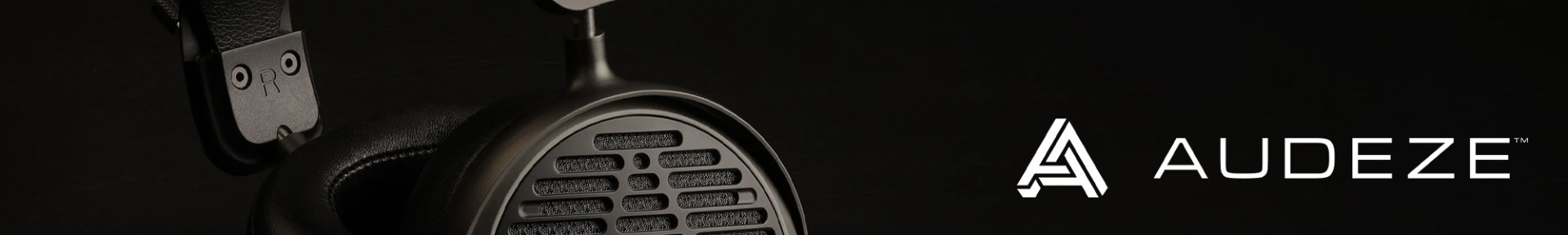 Close-up of a sleek, black Audeze headphone with a mesh grill. The logo "AUDEZE" is prominently displayed on the right against a black background.