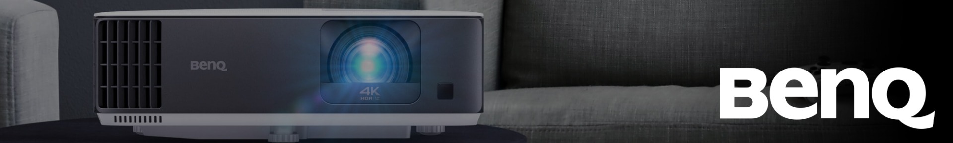 Sleek black and white BenQ 4K HDR projector on a dark surface, with a glowing blue lens. The BenQ logo is prominently displayed on the right.