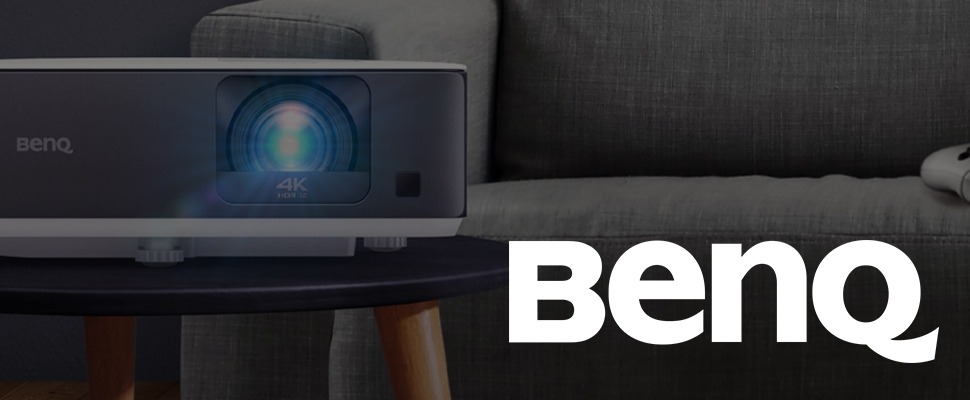 Sleek black and white BenQ 4K HDR projector on a dark surface, with a glowing blue lens. The BenQ logo is prominently displayed on the right.