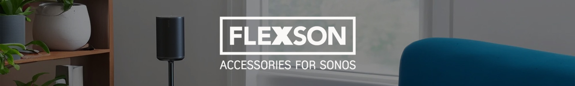 Cosy living room with a sleek black speaker on a stand, wooden shelf with plants, and modern décor. Text reads, “Flexson Accessories for Sonos.”