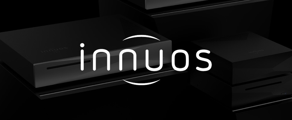 Sleek black audio device with geometric design on the front, featuring a slim slot and a subtle blue indicator. The "innuos" logo is prominently displayed.