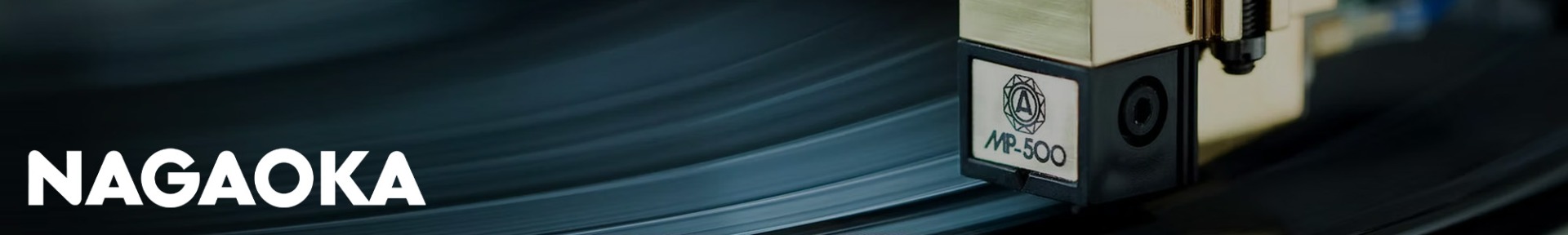 Close-up of a Nagaoka MP-500 cartridge playing a vinyl record, with the brand name "NAGAOKA" in bold white text on the left. The scene conveys precision and high-quality audio.