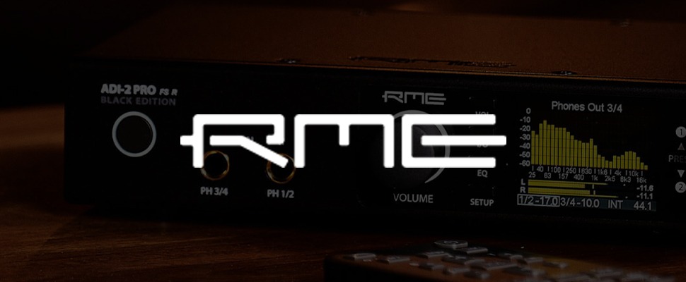 Close-up of an RME ADI-2 Pro FS R Black Edition audio interface. Shows branding, volume knob, and audio levels display. Modern and sleek design.