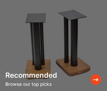 Two sleek speaker stands with black columns and wooden bases on a gray background. Text reads "Recommended: Browse our top picks" with an arrow icon.