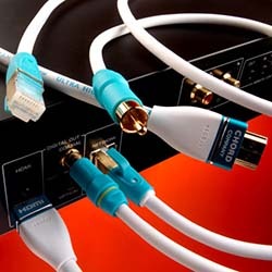 White cables with blue connectors are plugged into a black audio-visual device against a red background, conveying a tech-savvy, modern feel.