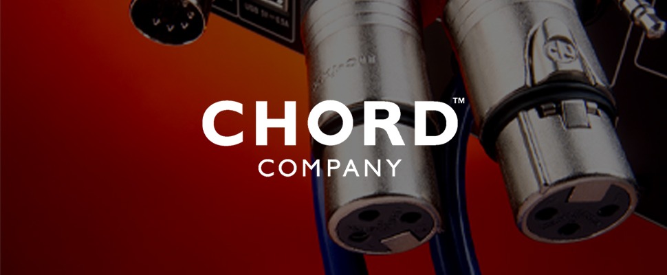 Close-up of audio cables and connectors against a gradient red background. The cables have metallic finishes with visible ports. Text: "Chord Company."