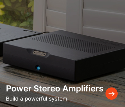 A sleek black stereo amplifier with vented top sits on a wooden surface. Text reads, "Power Stereo Amplifiers. Build a powerful system," with an arrow icon.