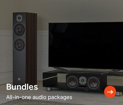 Home audio setup with a wooden tower speaker and a television on a stand featuring a soundbar. Text reads "Bundles: All-in-one audio packages."