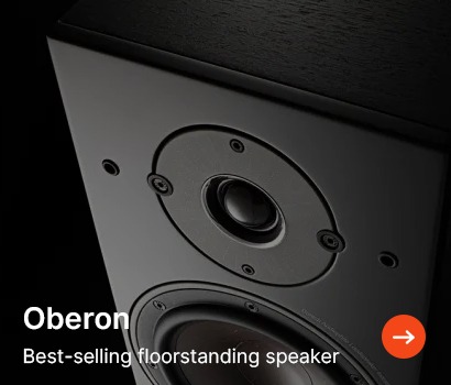 Close-up of a black floorstanding speaker with visible drivers and screws. Text reads "Oberon" and "Best-selling floorstanding speaker" with an orange arrow.