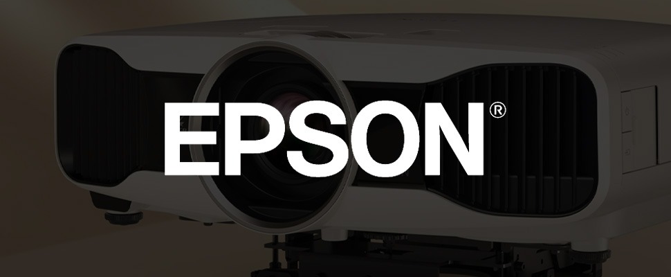 Close-up of an Epson projector lens with the brand's logo visible on the right. The image highlights the sleek design and advanced technology.