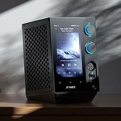 A sleek, black electronic device with a screen displaying music, two blue-lit knobs, and a perforated side. Ambient light creates a modern, stylish vibe.