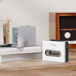 Retro-style cassette player displayed on a wooden table. A vintage speaker is in the background.