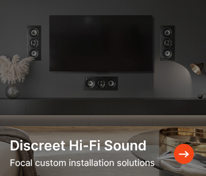Modern living room with sleek wall-mounted TV and discreet Focal Hi-Fi speakers. Stylish, minimalist decor with soft lighting and calming tones.