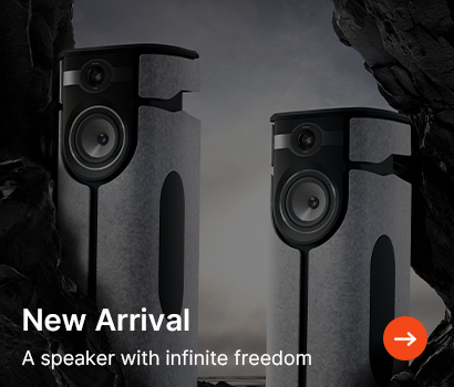 Two sleek, tall speakers stand amidst dark, rocky surroundings with a cloudy sky. Text reads "New Arrival: A speaker with infinite freedom."